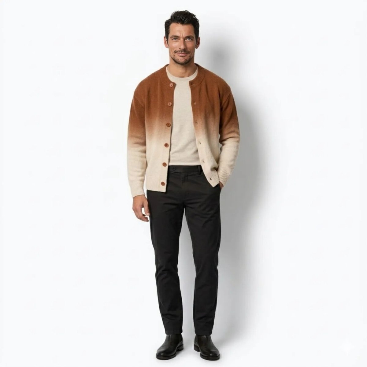 Man wearing a rust khaki to cream Theodore gradient knit cardigan sweater, open over a beige t-shirt and black trousers, full body front view.