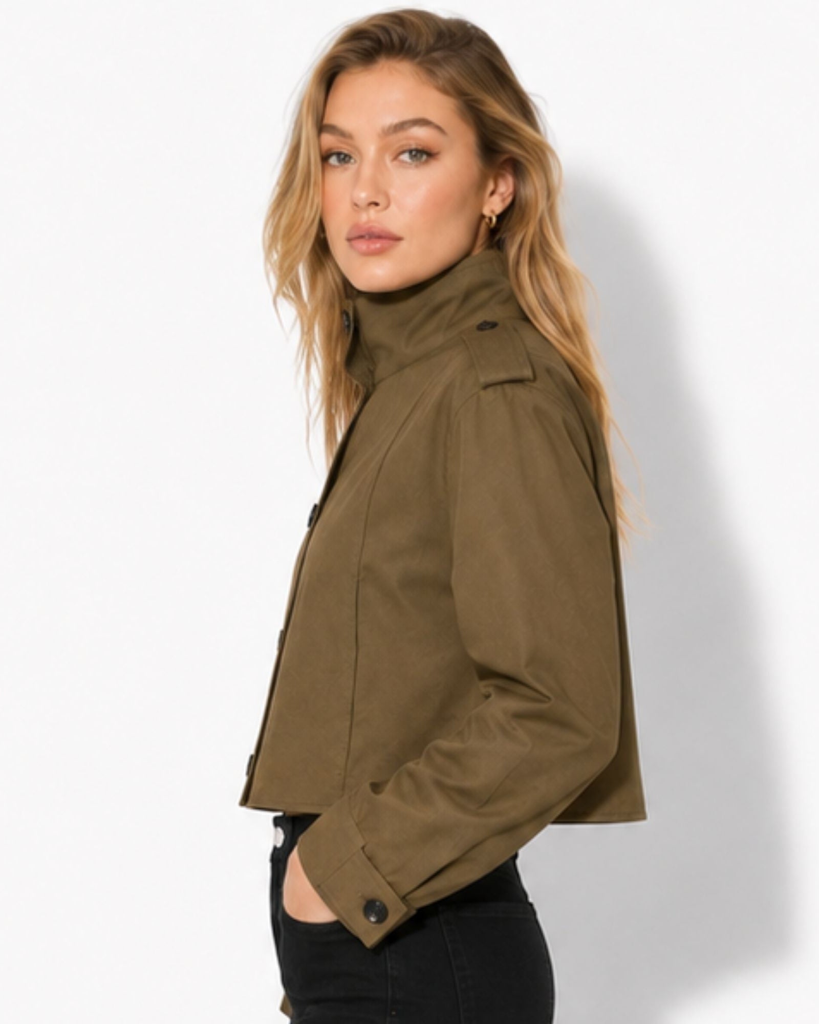 Side profile of woman modeling a structured khaki green military crop jacket with tailored shoulder epaulets.