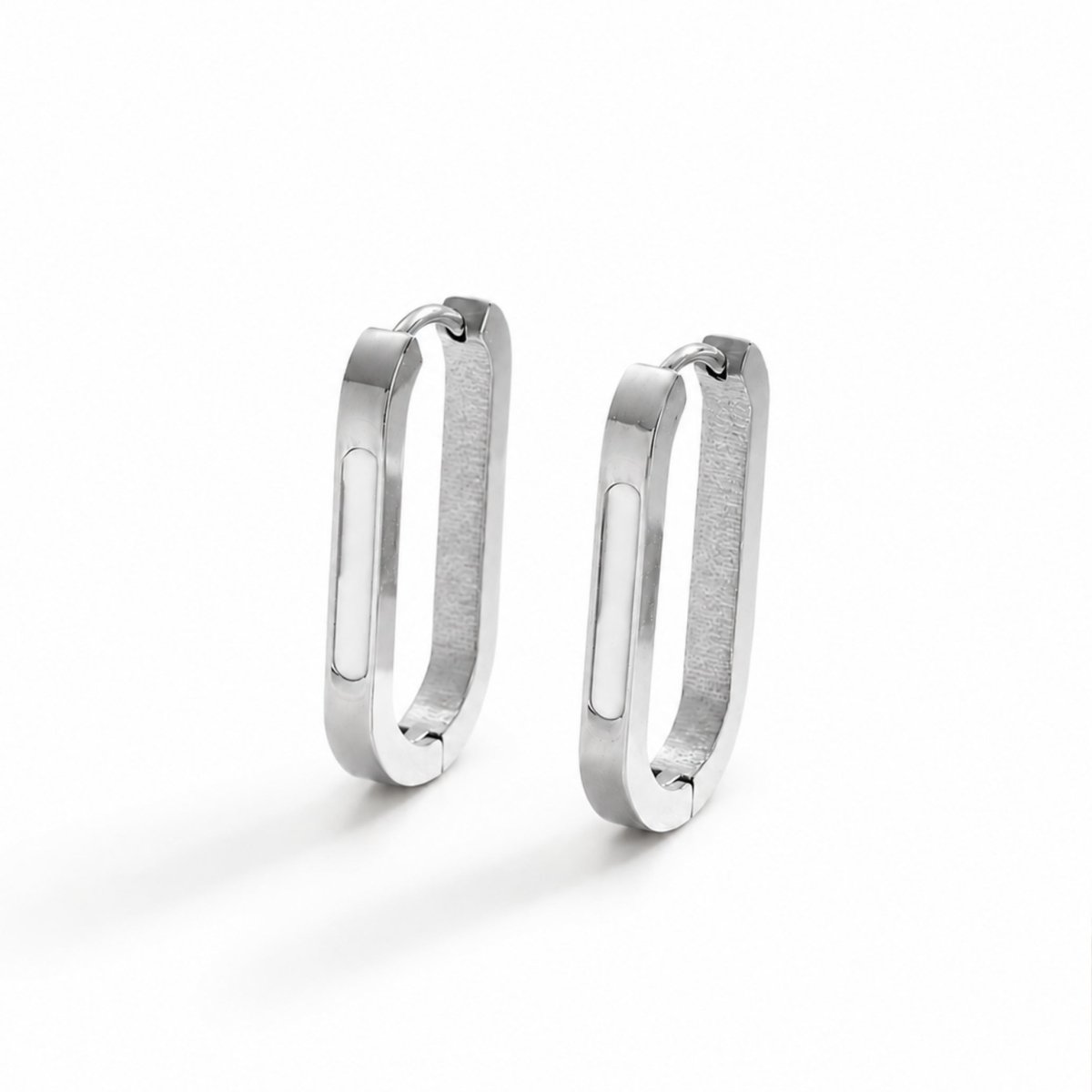 Portrait of a blonde female model wearing minimalist silver rectangular hoop earrings showcasing versatile everyday luxury jewelry styling.