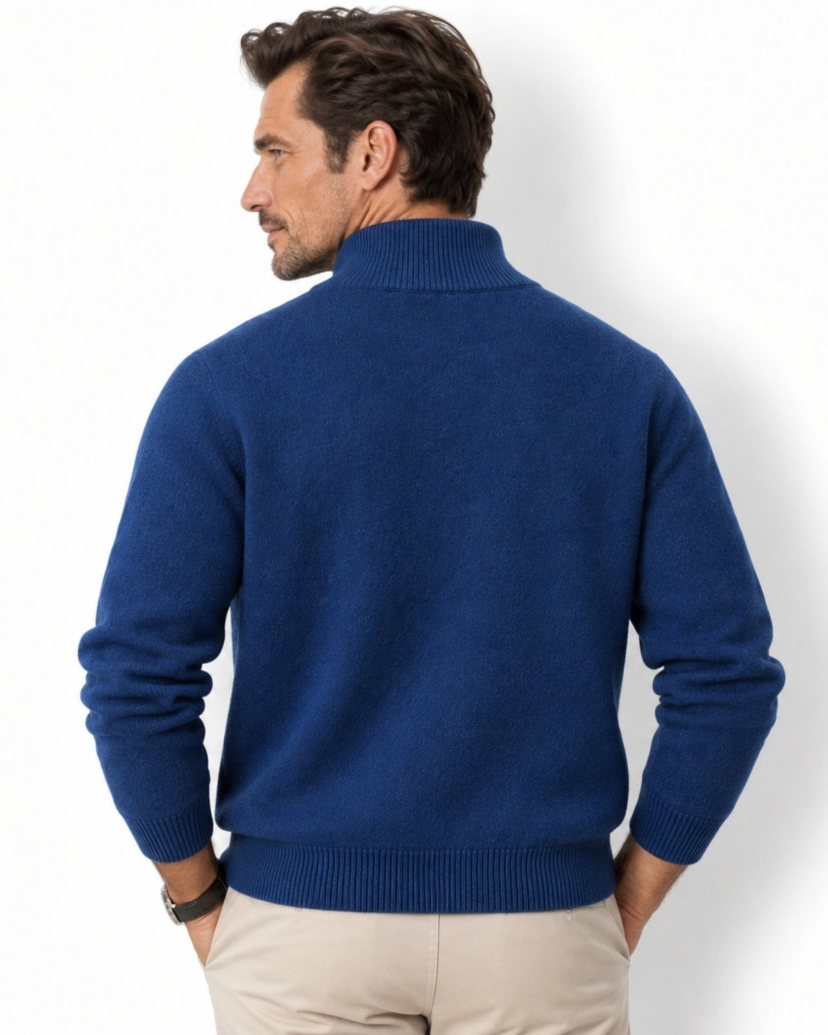 A man wearing a royal blue knit mock neck sweater, shown from the back, paired with beige trousers against a clean white background.
