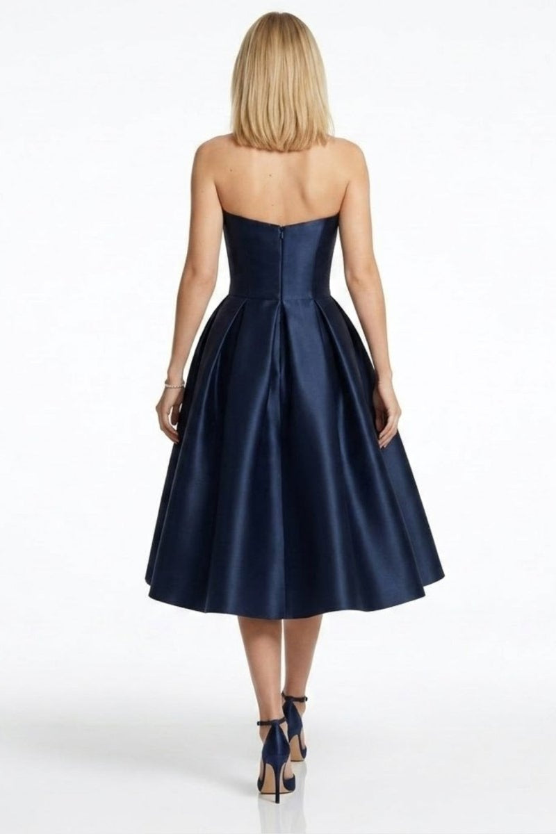 Back detail of navy satin formal party dress showing concealed zipper and pleated A-line skirt.