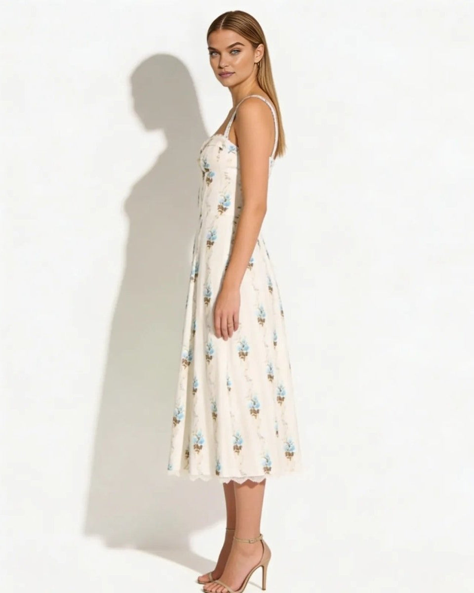 Side profile of a model in the Nefeli cream floral bustier midi dress, showcasing the A-line silhouette and midi length.