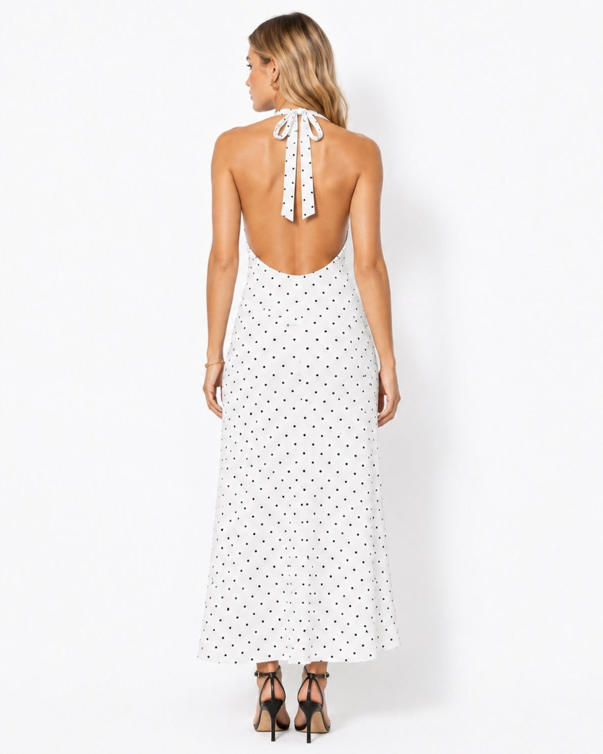 Back view of a stunning backless tie halter dress in white with black spots, highlighting the elegant bare back design.