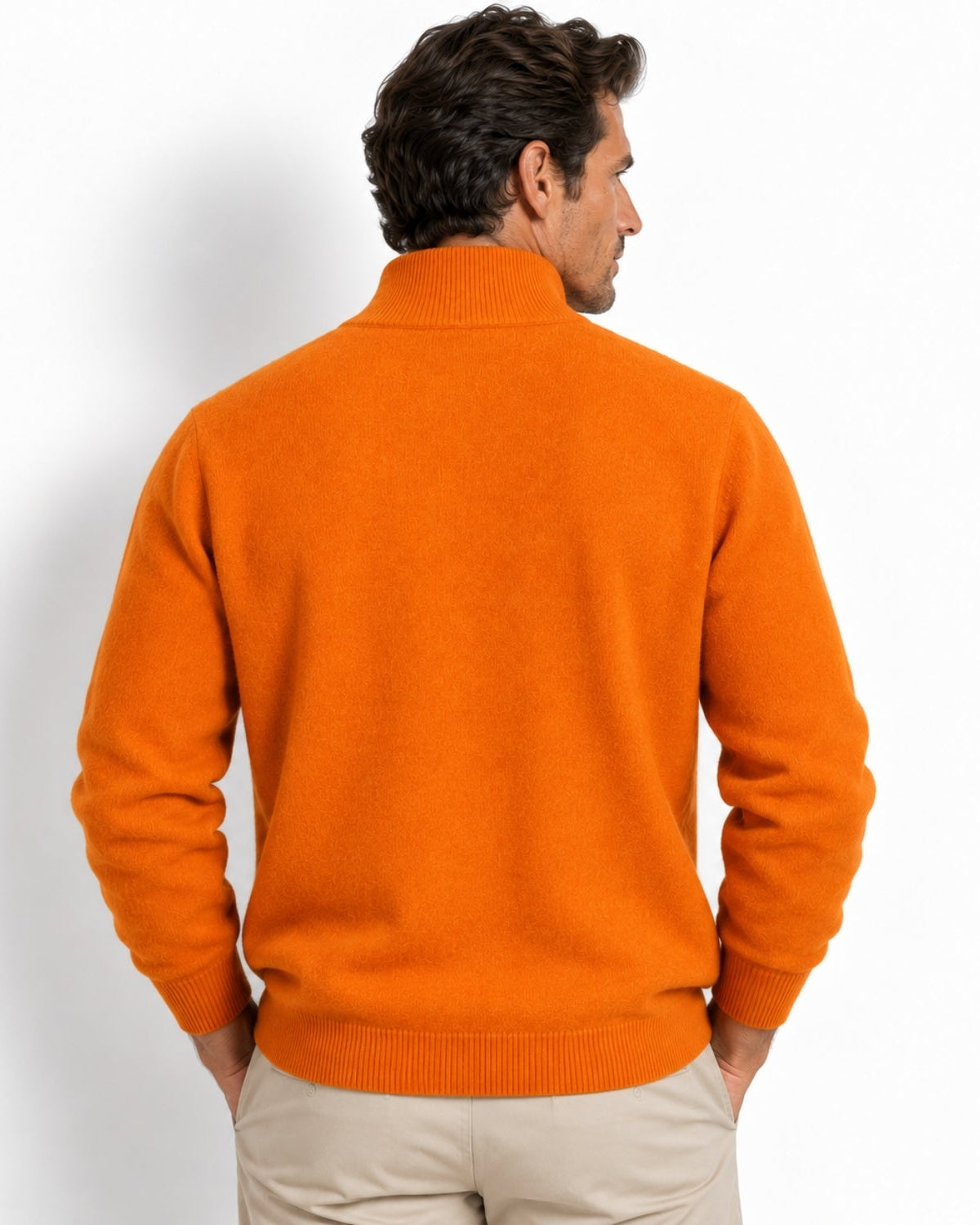 A man wearing a bright orange knit sweater, shown from the back against a clean white studio background.