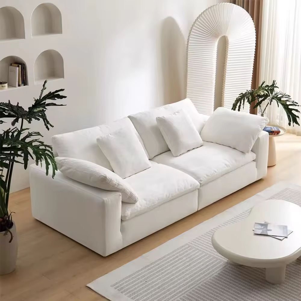 Front view of the Kouvr oversized white cloud modular sofa with deep seats in a modern, minimalist living room setting.