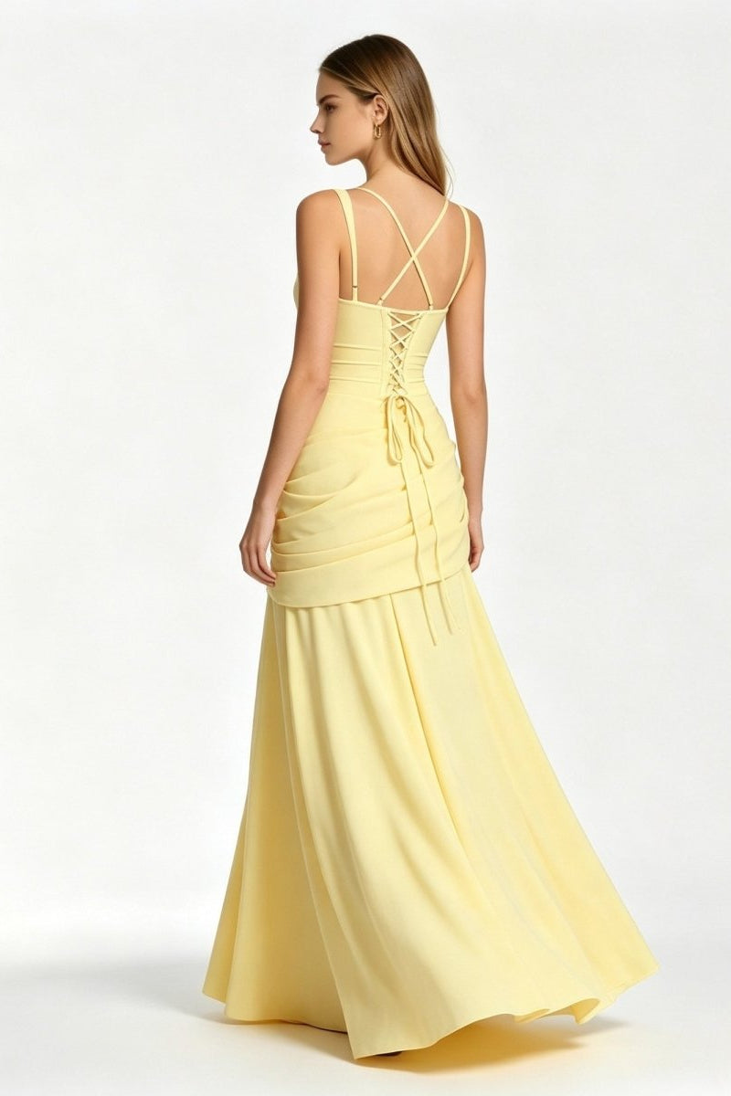 Back view of a pale yellow formal maxi dress showcasing an adjustable lace-up corset back, spaghetti straps, and trailing fabric ties.