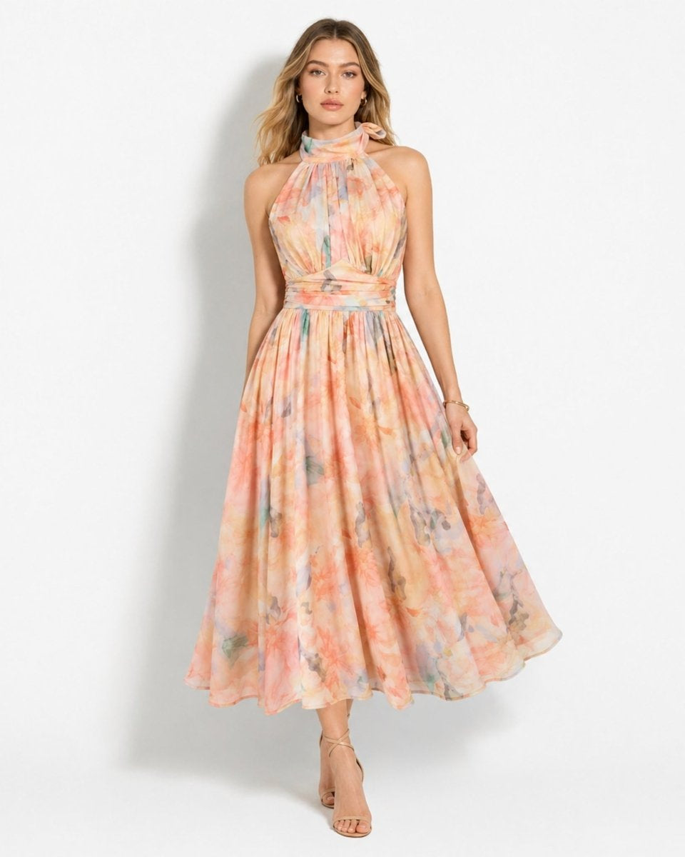 Woman wearing pastel floral halter midi dress standing facing forward with nude heels