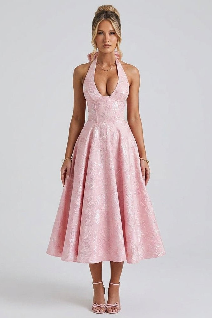 Front view of fashion model wearing Kouvr pink floral jacquard halter midi dress with corset bodice and deep v-neck.