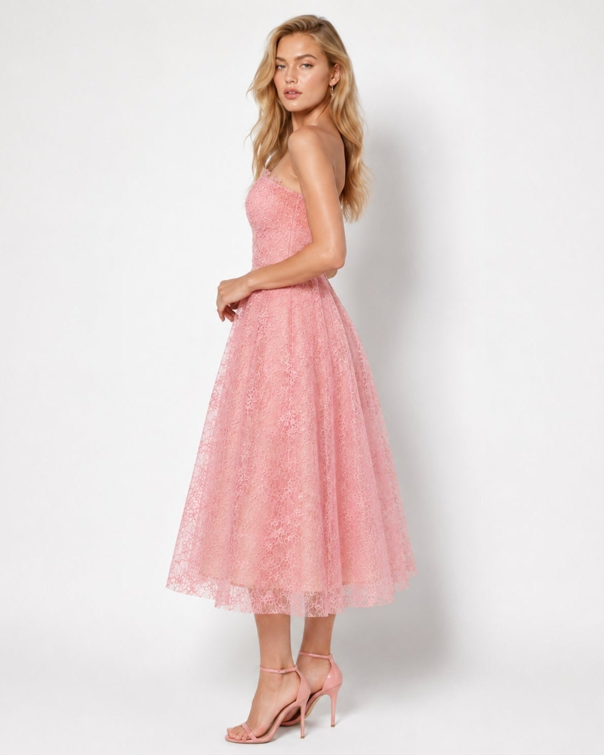 Rear view of soft pink luxury fit and flare midi gown highlighting the seamless back zipper, tailored waist, and delicate scalloped lace hem.