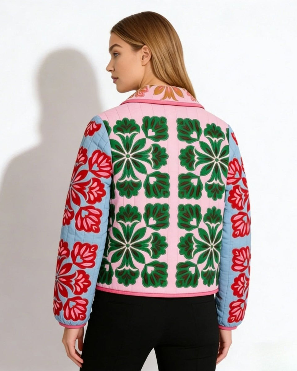 Back view of the quilted jacket, highlighting the symmetrical green floral embroidery pattern on the pink back panel.