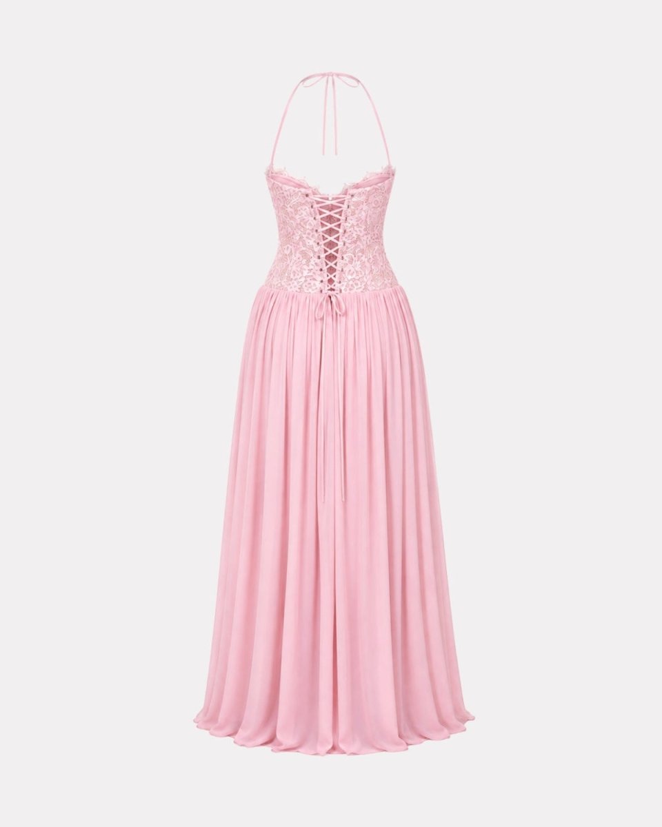 A light pink halter-neck maxi dress with a lace-up corset bodice and a flowing pleated skirt, shown against a plain light gray background.