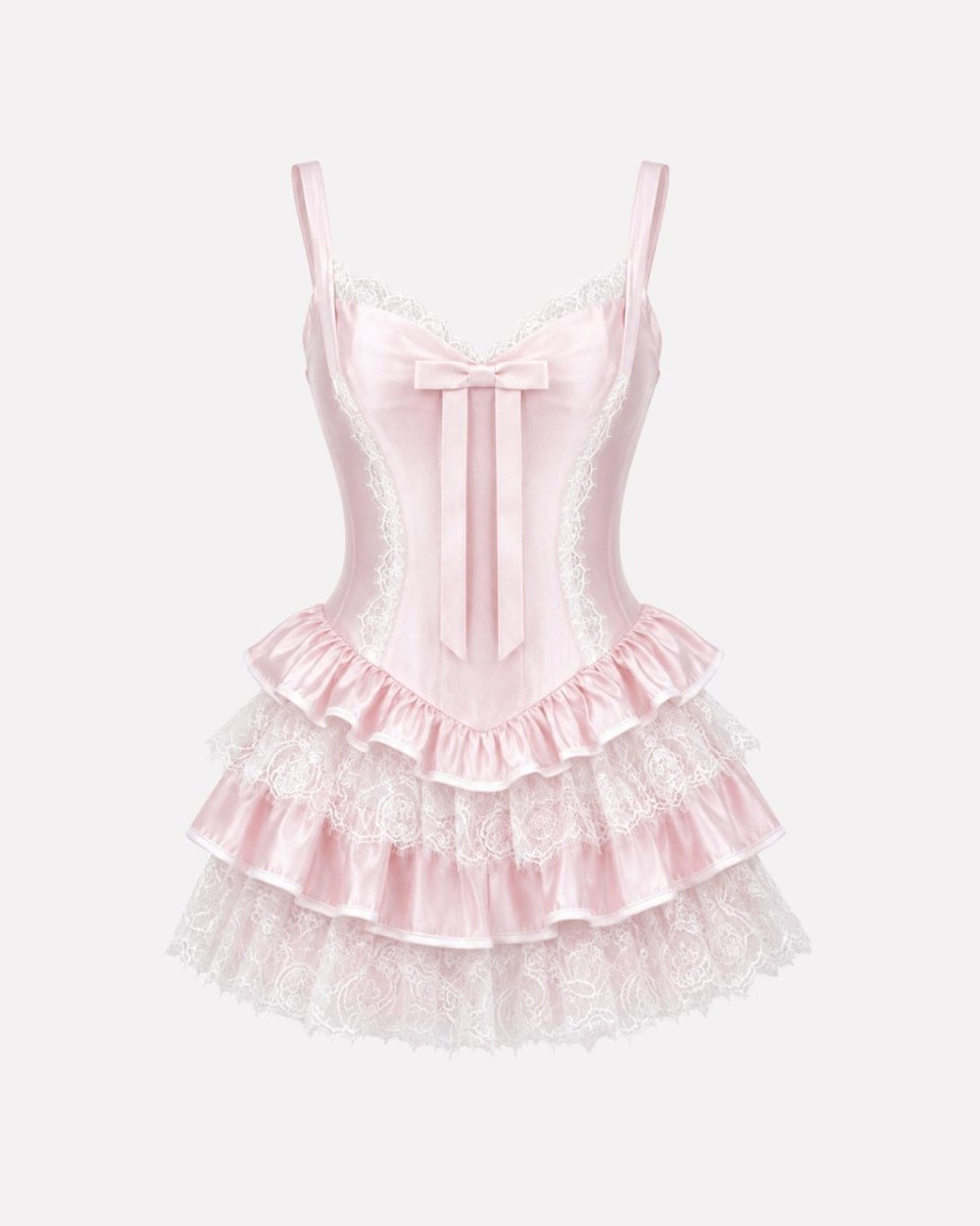 Product shot of a baby pink satin and lace tiered babydoll dress with a structured sweetheart neckline.