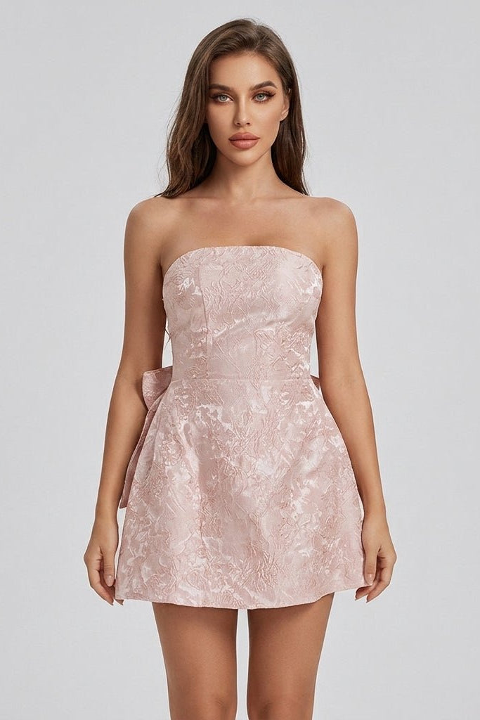 Close up of affordable luxury pink strapless party dress showing fitted bodice and textured woven floral fabric.