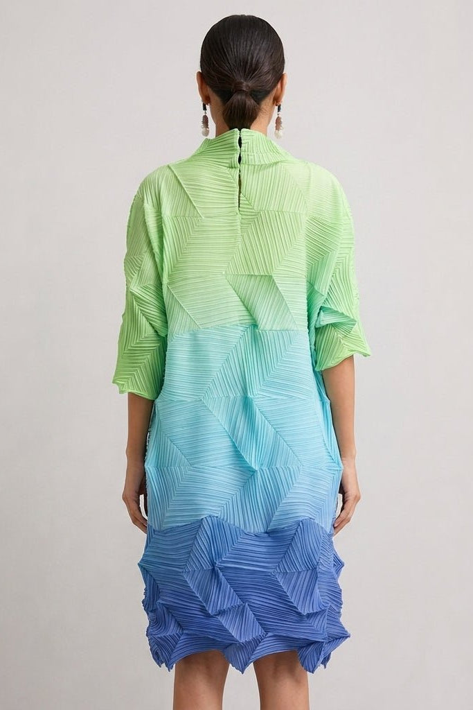 Back view of the Fenlo Form structural plisse colorblock dress showing the relaxed fit, back neckline seam, and vibrant blue hem.