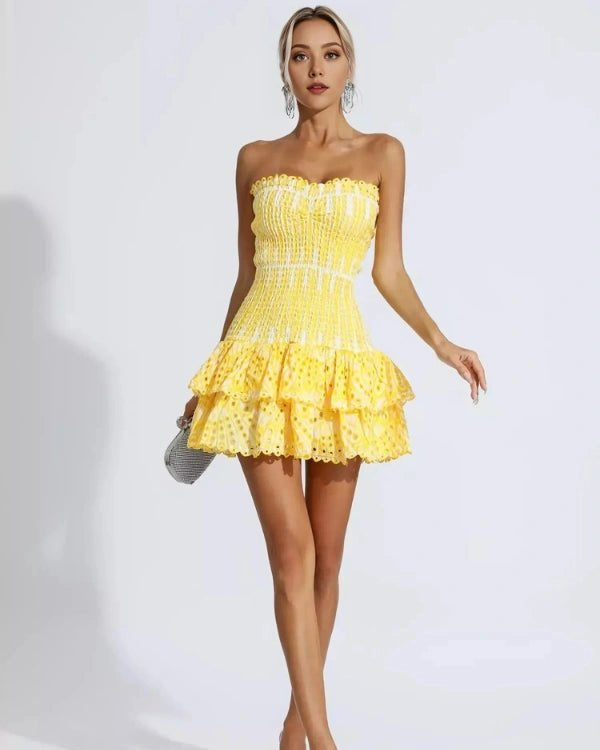Woman wearing a yellow strapless dress on a white background