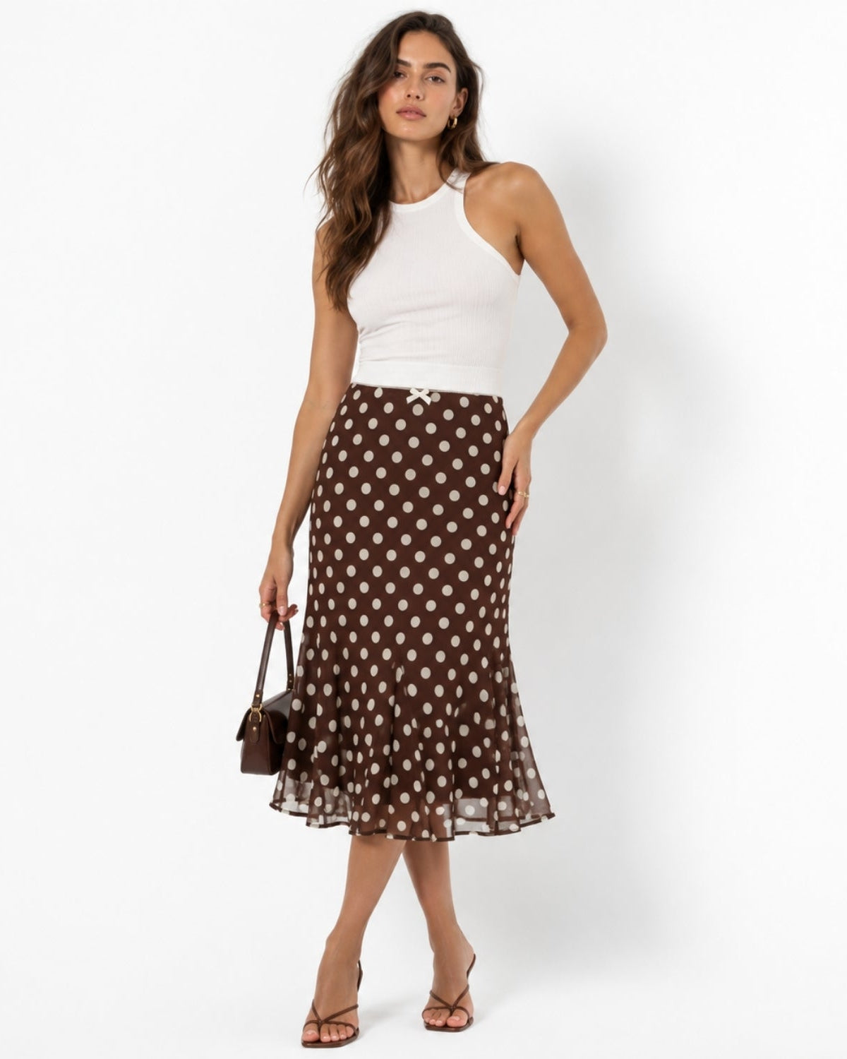Elegant brown polka dot midi skirt featuring a fluted hem and delicate waist bow 