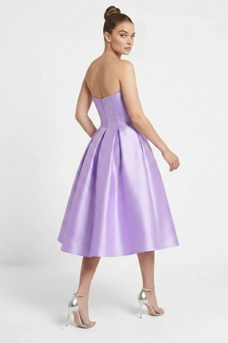 Back view of the Fenlo Form purple formal cocktail dress highlighting the invisible zipper and sweeping pleated skirt.