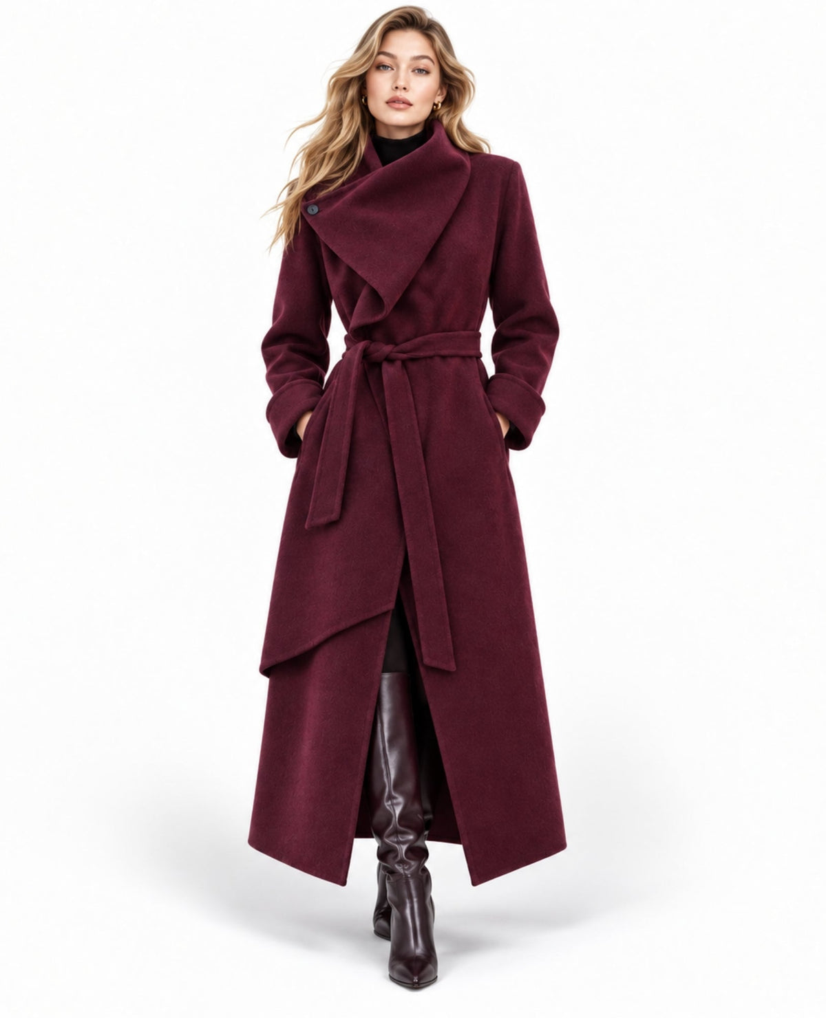 A woman modeling a long, dark burgundy wrap coat with a tie belt, paired with dark brown leather boots, against a plain white studio background.