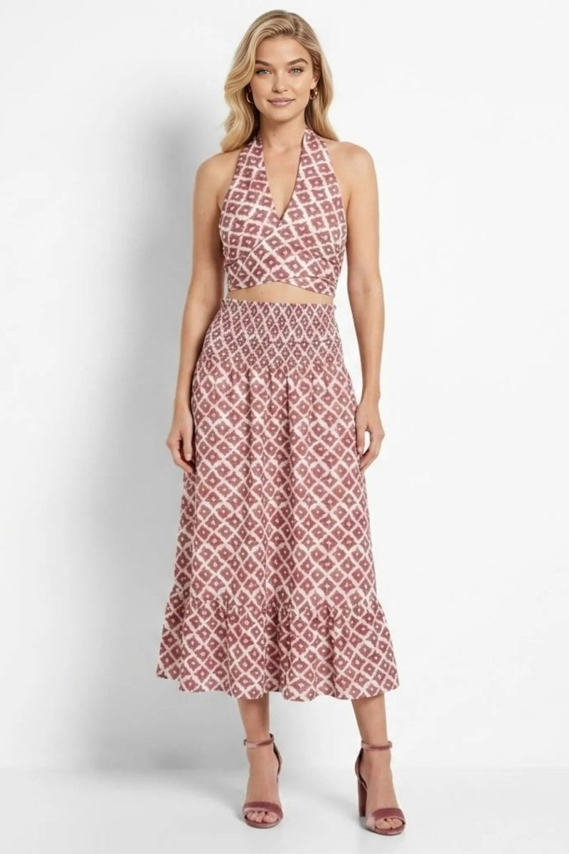 Model wearing Fenlo Form red geometric print halter crop top and smocked midi skirt two piece set facing forward.