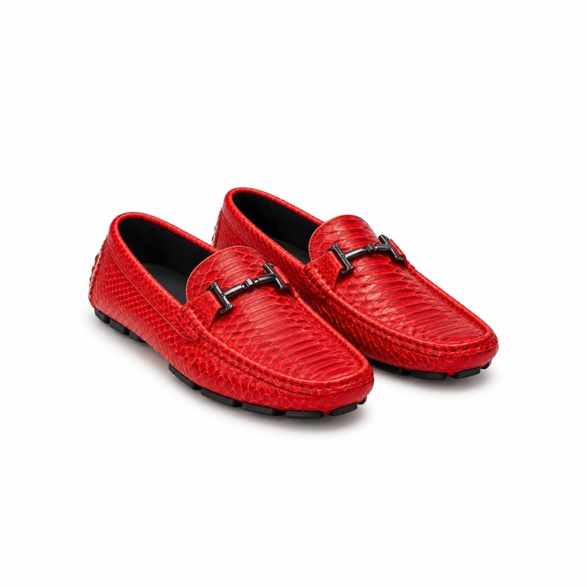 A pair of bright red textured leather loafers with black metal hardware, displayed on a clean white background.