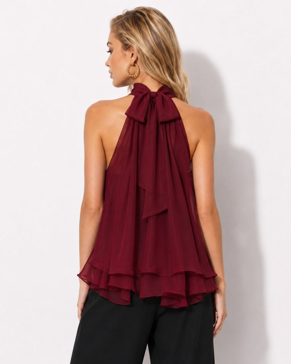 Back view detailing the adjustable oversized bow tie on a red layered chiffon halter top by luxury fashion brand