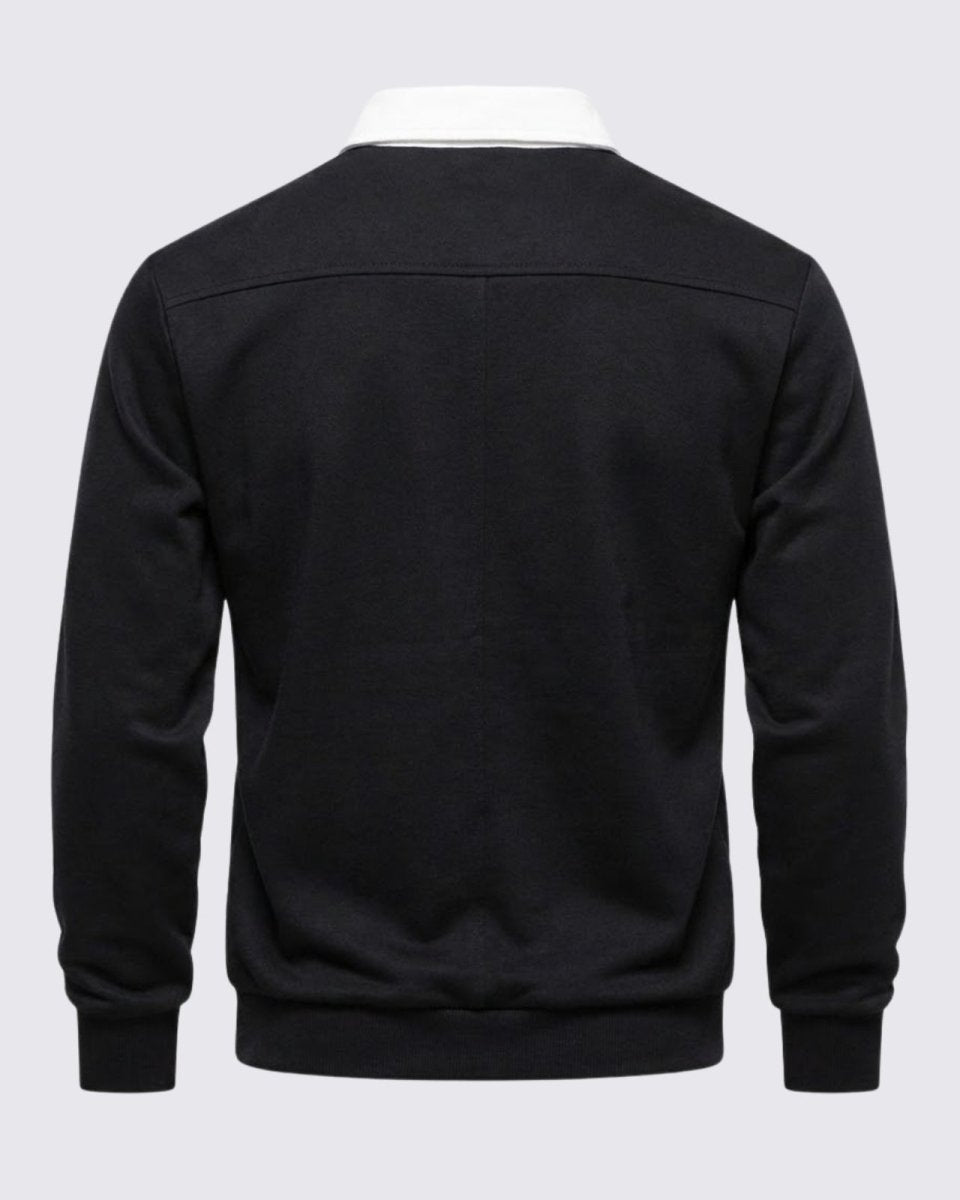 Flat product shot of the back of the Rhodes black knit polo, highlighting the shoulder seam construction and shape.
