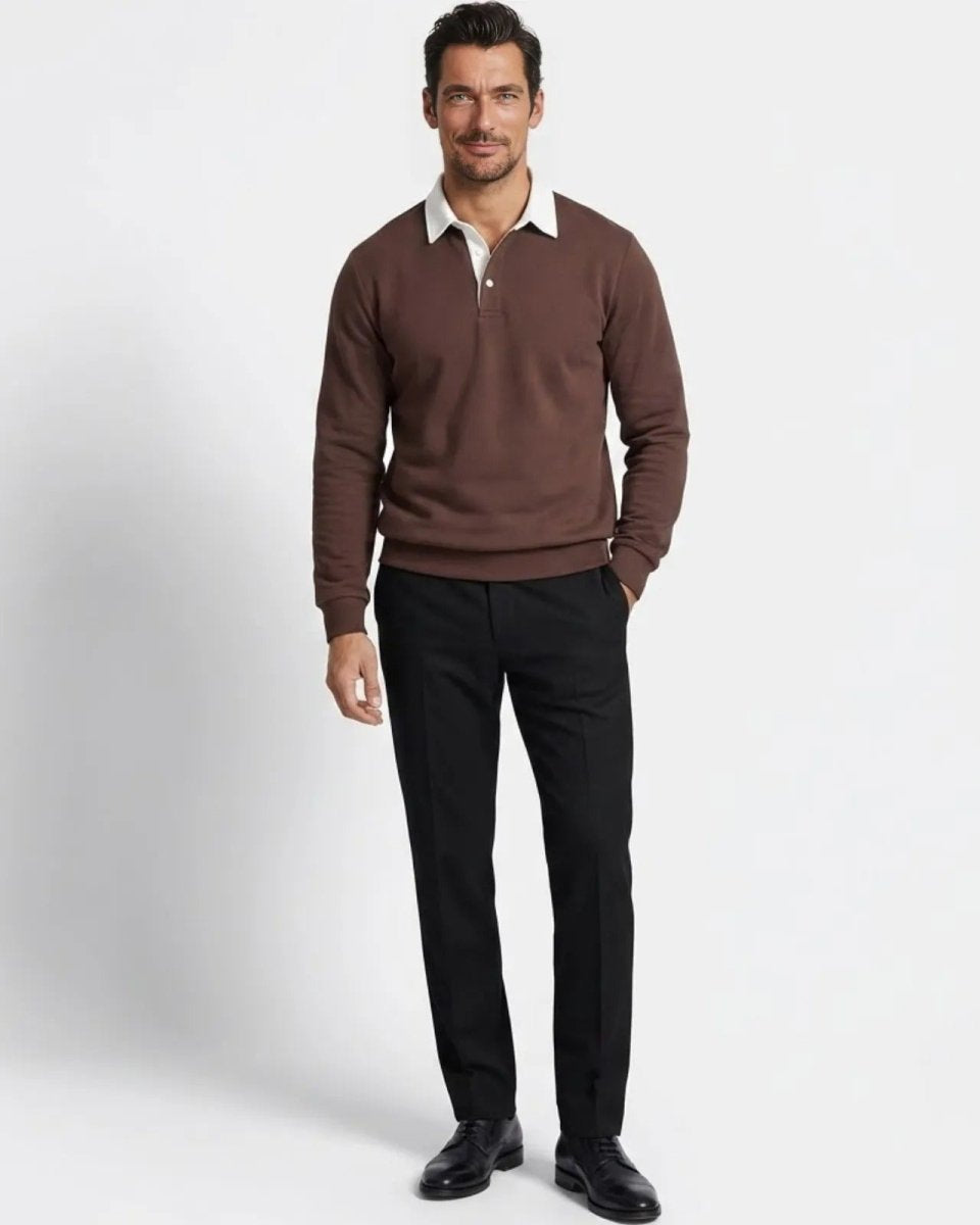 Man wearing the Rhodes dark brown long sleeve knit polo sweater with a white contrast collar, styled with black tailored trousers.