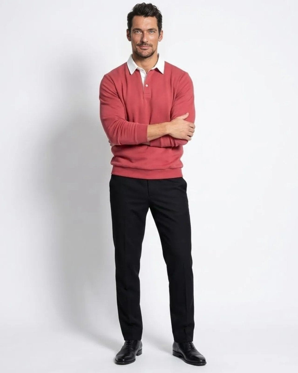 Model wearing the Rhodes long sleeve polo sweater in rosewood red, viewed from the front with arms crossed.