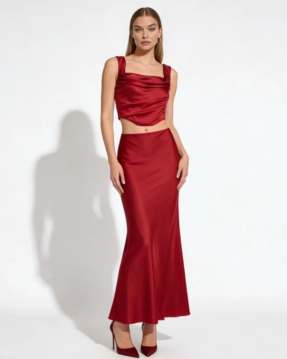 Model wearing the Rona red satin set, featuring a cowl neck crop top and matching long maxi skirt, on a white background.