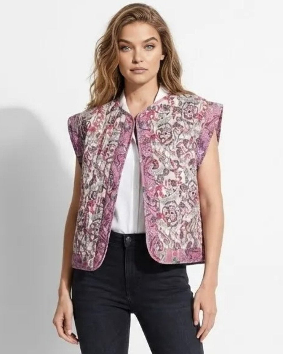Model wearing the Rose quilted floral paisley vest in pink and mauve, styled open over a white collared shirt and black denim jeans.