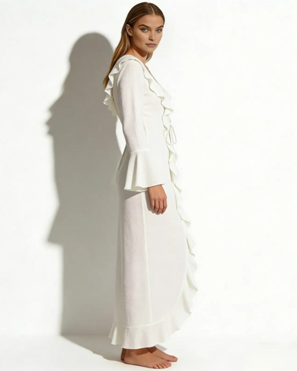 Side view of a model in the Roseta white long sleeve ruffle beach robe, showcasing the flowing silhouette.