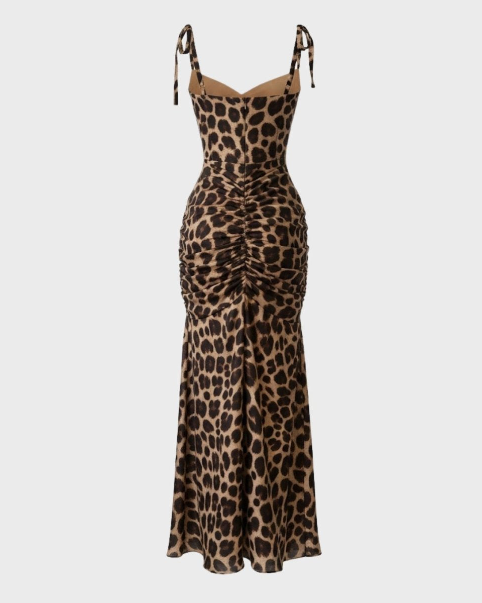 Flat lay image of the back of a leopard print maxi dress, detailing the full-body ruching and adjustable shoulder ties.