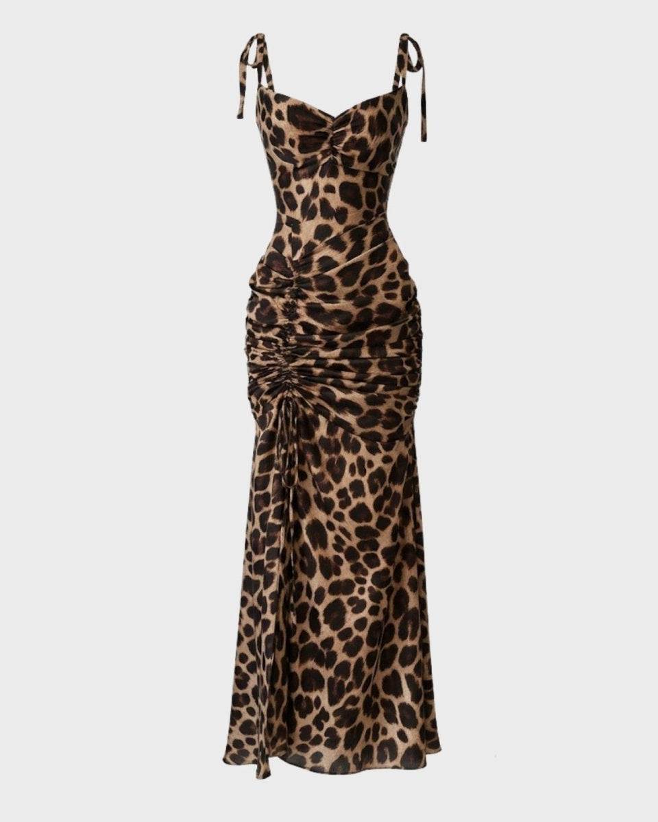 Flat lay image of a leopard print maxi dress showing the front, with details of the sweetheart neckline, tie straps, and drawstring ruching.