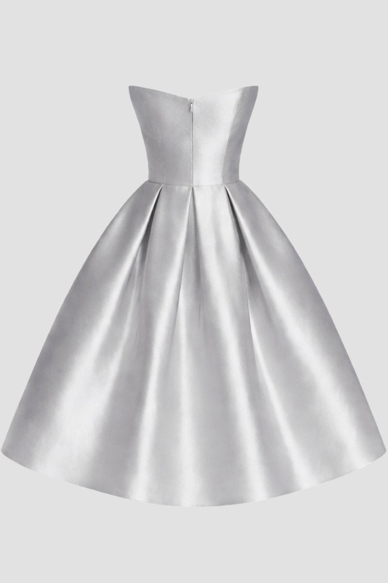 Studio ghost mannequin back view of a silver A-line cocktail dress showing bodice seaming and back zipper closure.