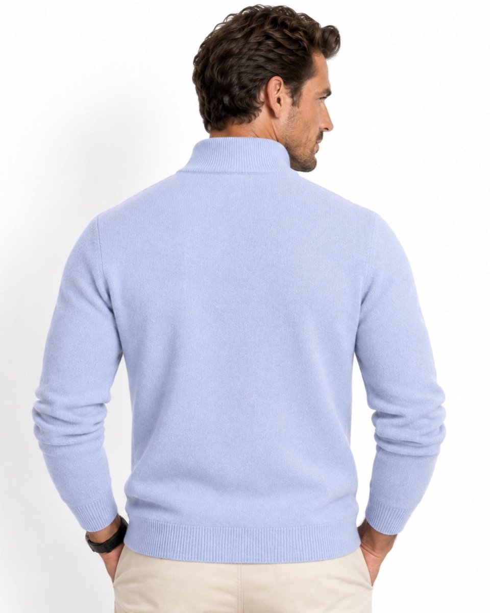 A man shown from the back wearing a sky blue knit mock-neck sweater and beige trousers, photographed against a clean white studio background.