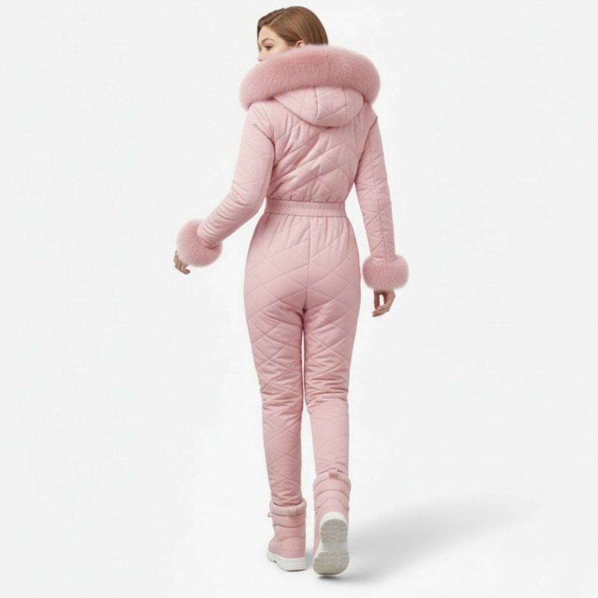 Back view of a model in the  Skyla pink ski suit, highlighting the quilted pattern and belted waist.