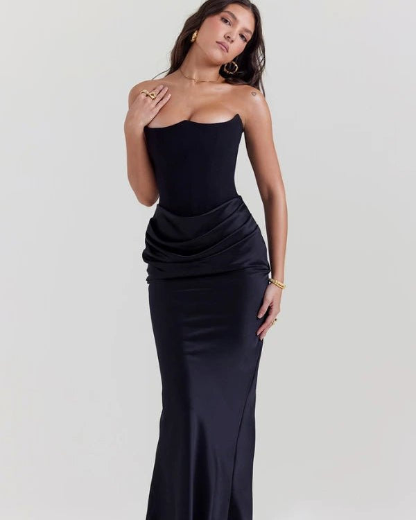 Woman wearing a strapless black evening gown on a white background