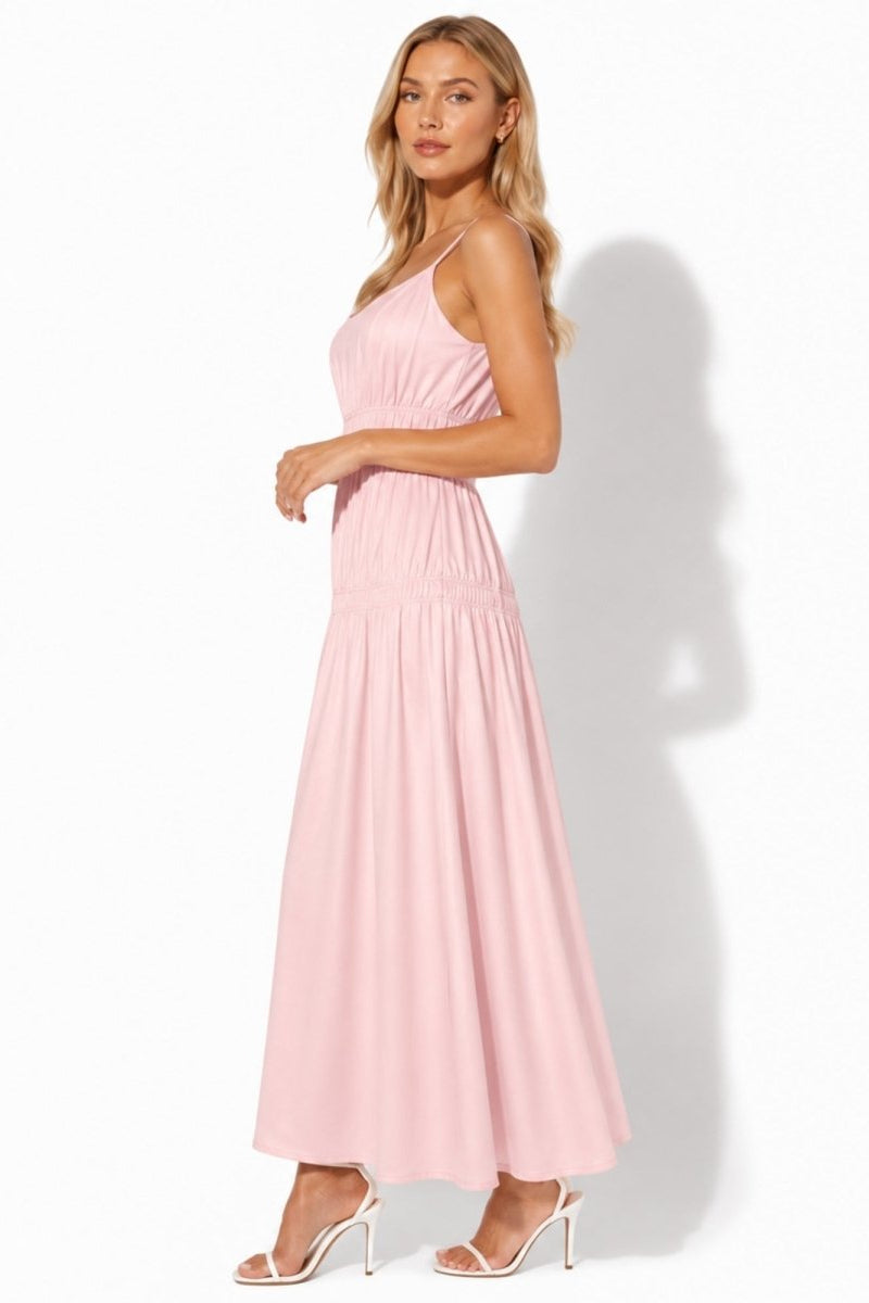 Side profile of a light pink flowy maxi sundress showing wide smocked bodice details
