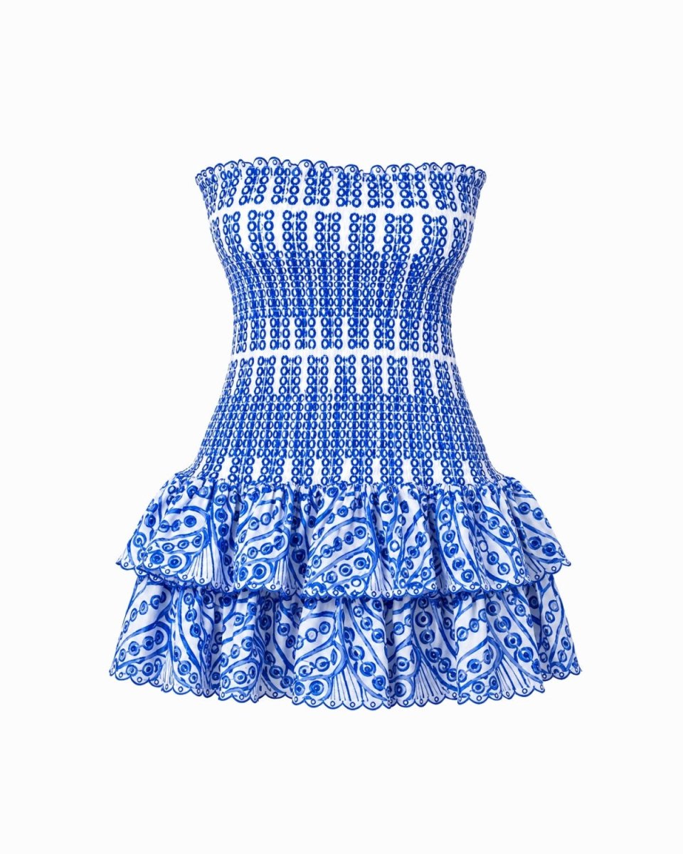 A strapless smocked mini dress featuring a blue and white paisley pattern, with a ruffled hem and a smocked bodice, shown against a plain white background.