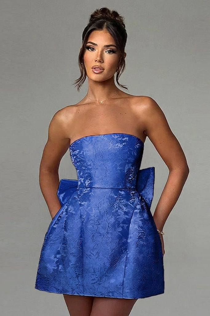 Model posing in Kouvr elegant A-line cocktail dress showcasing the textured floral blue jacquard fabric.
