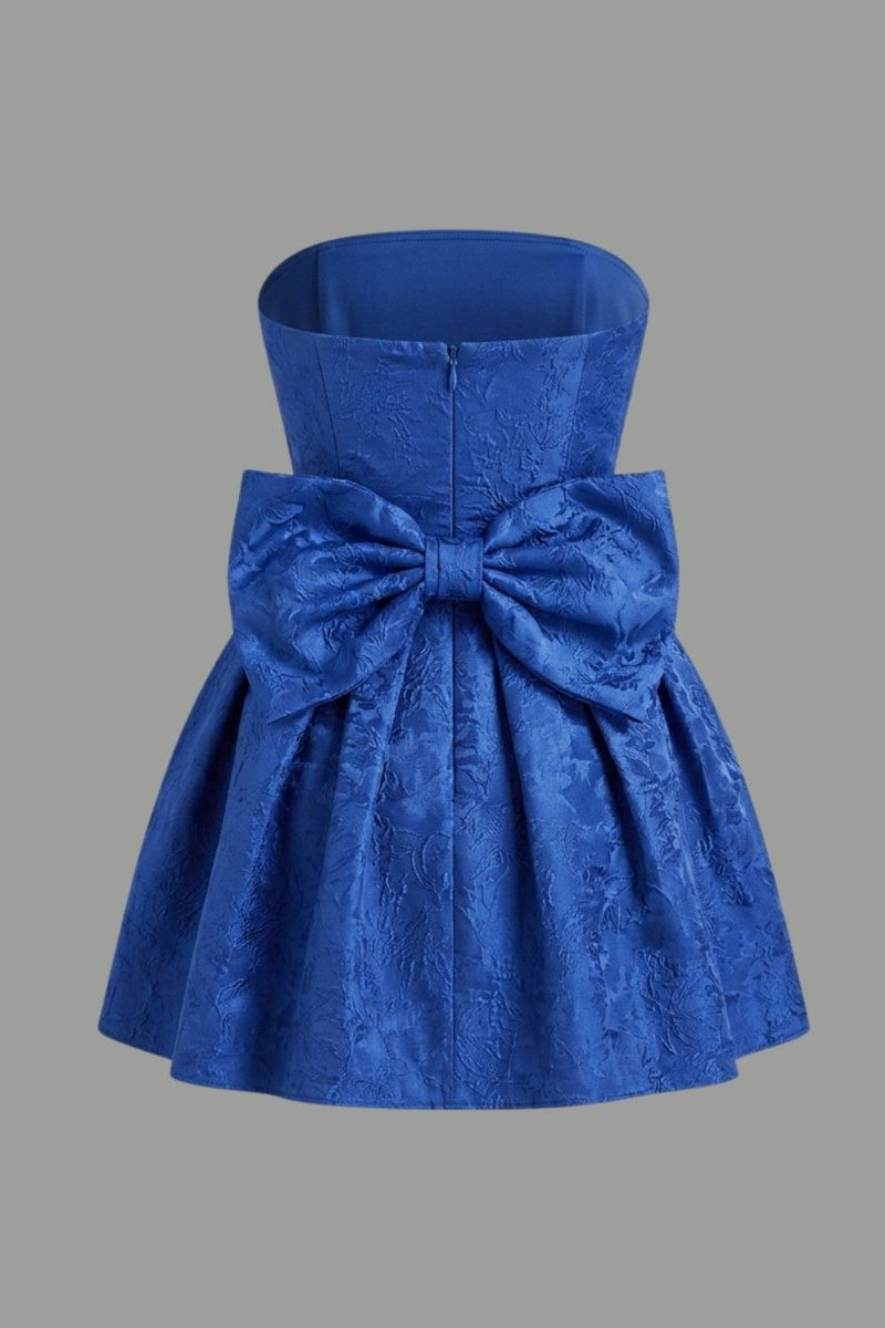 Ghost mannequin back view of blue strapless evening attire featuring a large attached architectural bow.