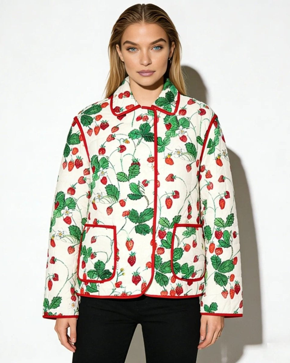 Model wearing the strawberry garden quilted jacket with red trim, styled with black pants against a white background.