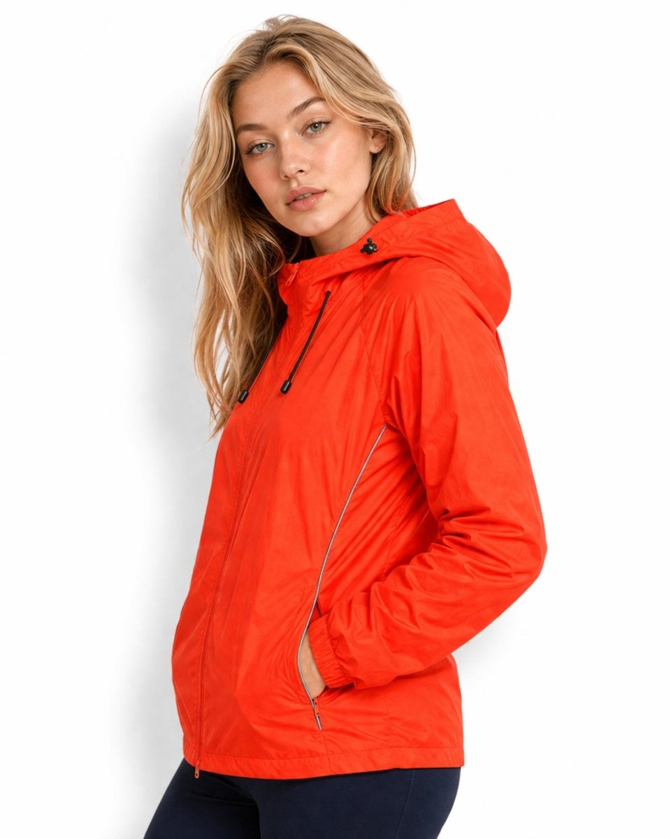 Side profile of woman in neon orange athletic shell jacket highlighting the high-visibility reflective piping along the sleeve seams.