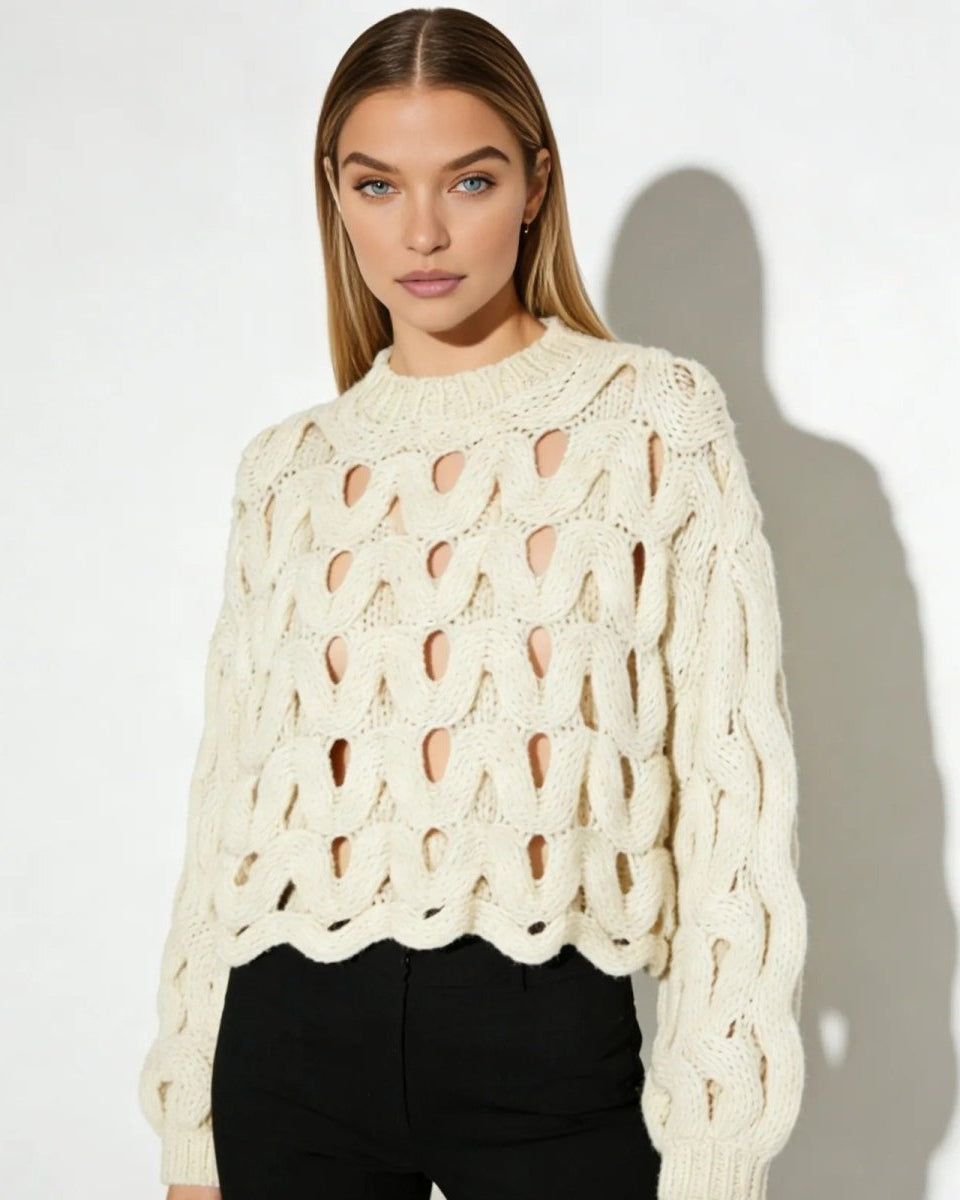 Model wearing the Vanice open-knit sweater in ivory, styled with black high-waisted trousers.