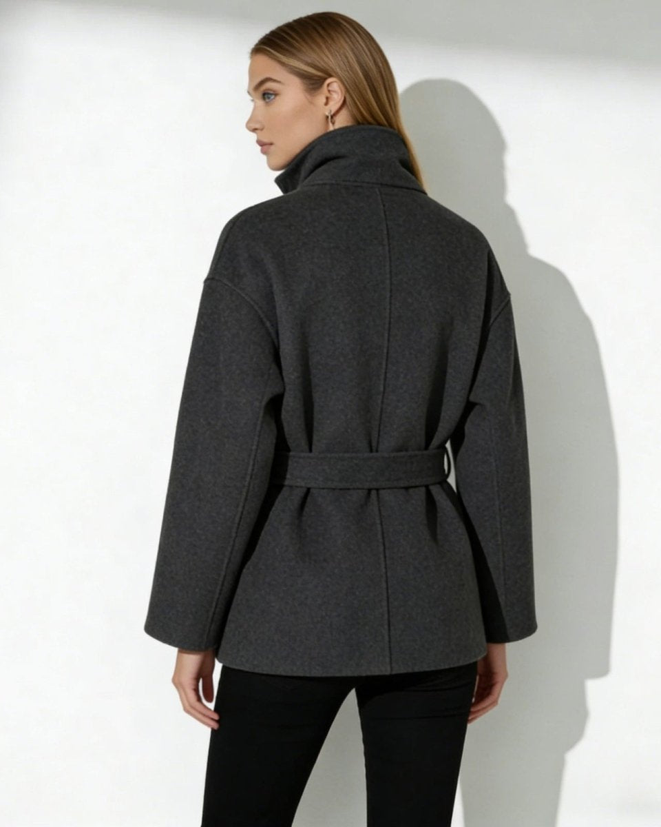 Back view of the Verna belted wool coat in dark gray, highlighting the clean lines and belt detail.

