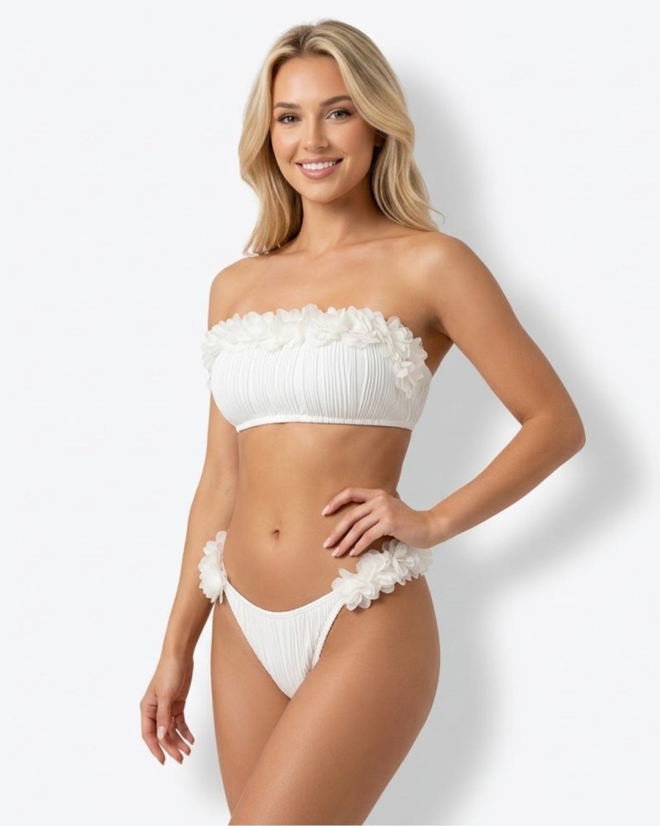 Beautiful woman wearing a luxury white strapless bandeau bikini set with 3D floral appliques and textured pleats