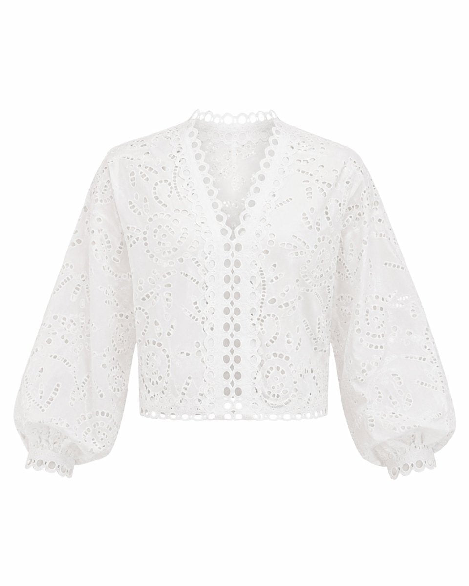 Flat lay front view of the white eyelet V-neck summer blouse featuring intricate cutwork by designer brand Fenlo Form.