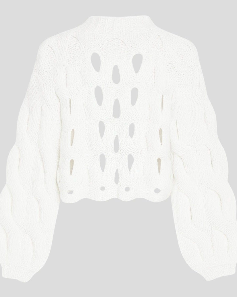 Flatlay product shot of the white cutout chunky knit sweater, back side, on a light grey background.