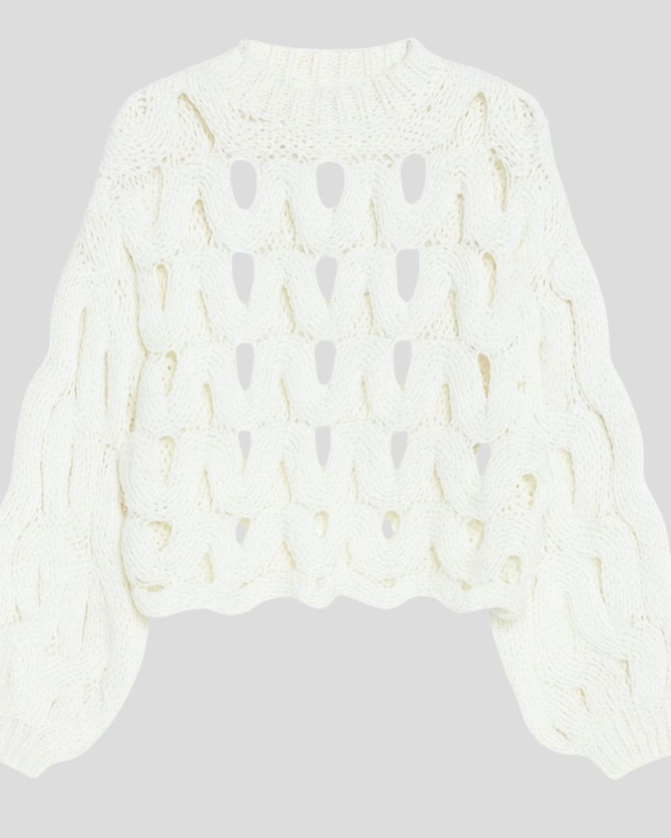 Flatlay product shot of the white cutout chunky knit sweater, front side, on a light grey background.