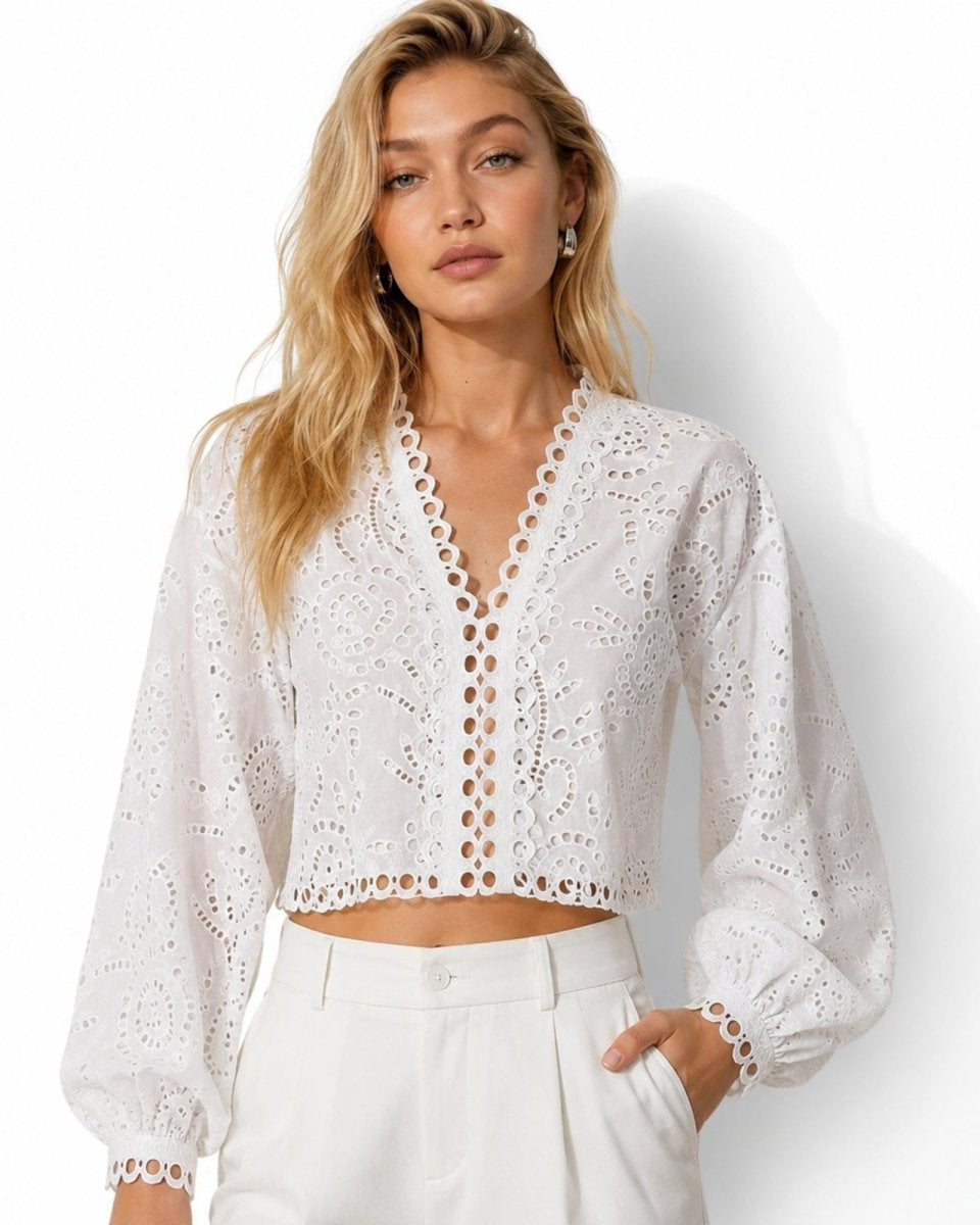 Front view of the Fenlo Form white eyelet lace V-neck crop top with long balloon sleeves styled with high-waisted white trousers.
